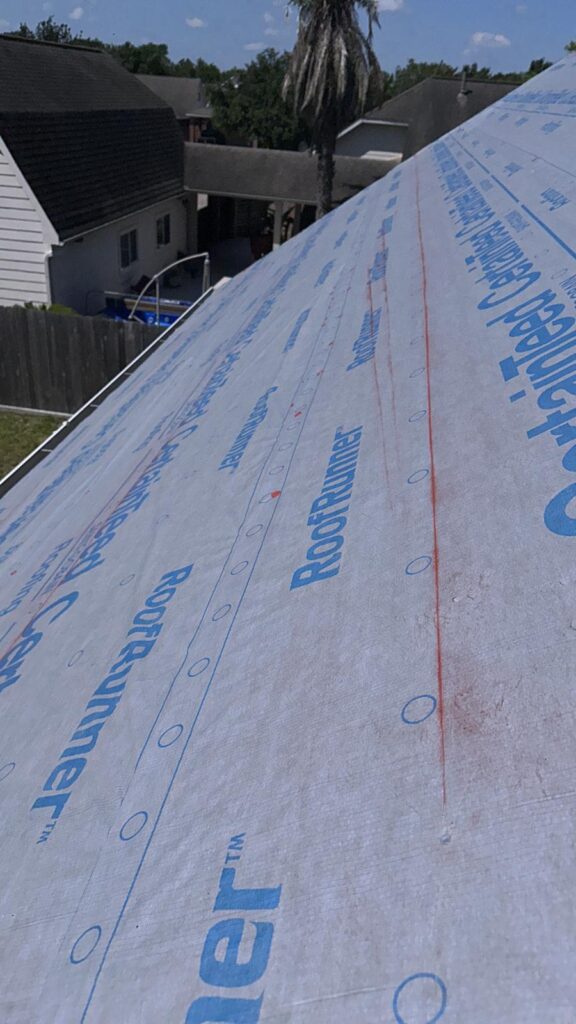 A roof in the process of being built, sealed properly with plastic sheeting to prevent moisture-based roof damage.